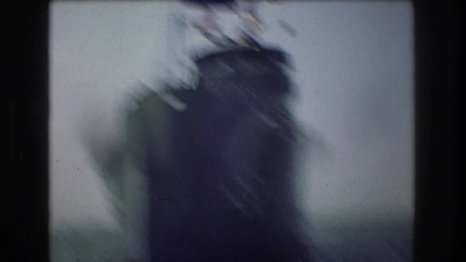 Soft, blurred 8mm frame showing what appears to be a ship bow or superstructure with a small flag near New York City harbor context from the clip metadata.