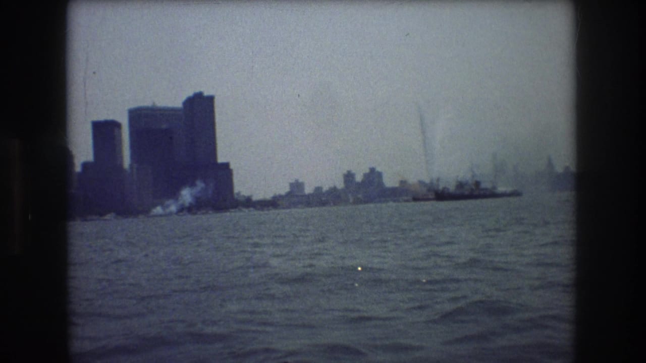 Hazy city skyline across harbor water with film gate edges visible.