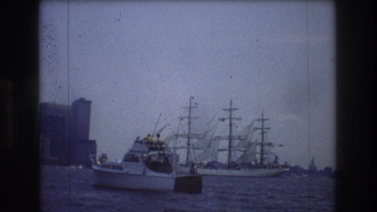 Small motorboat passes a multi-masted sailing ship in New York Harbor.