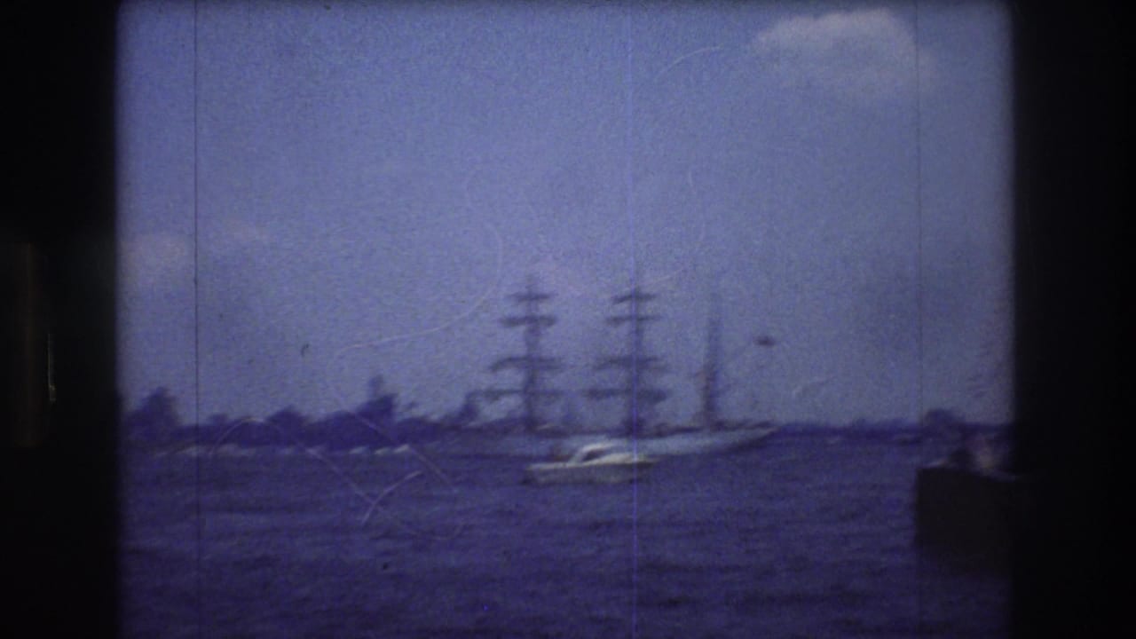 Sailing ship farther across the water with dark frame-edge obstruction at right.