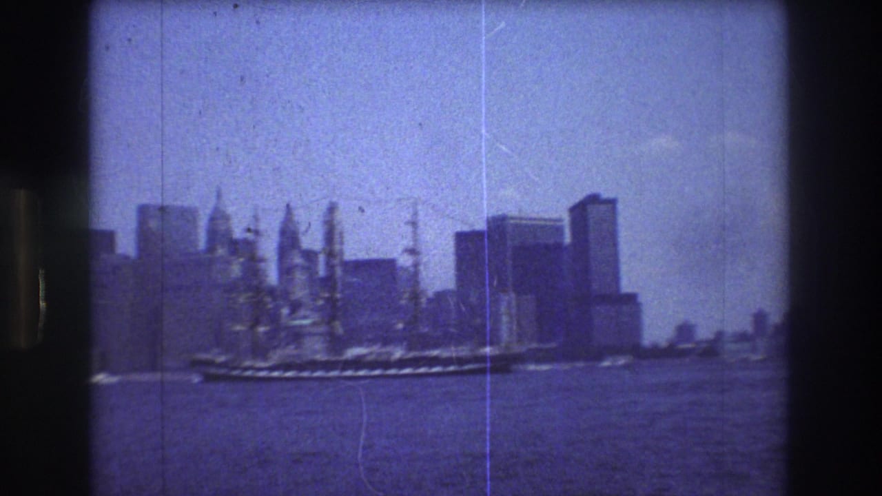 A 1976 New York City harbor frame shows a large multi-masted sailing ship moving across the water with Manhattan skyscraper silhouettes behind it, rendered in grainy blue-purple 8mm texture.