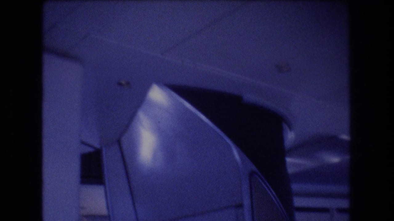 Close view of airplane cabin interior with overhead paneling and curved compartment detail.