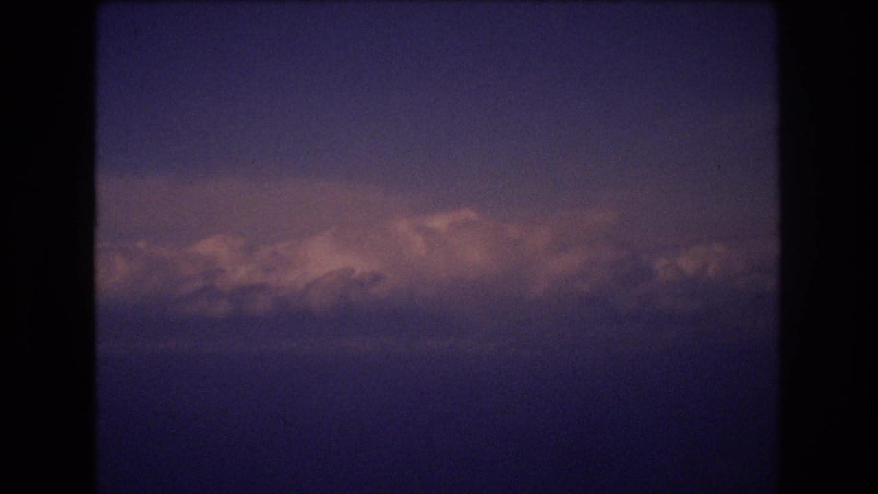 Cloud bank across a dark blue sky with soft pink light near the horizon.