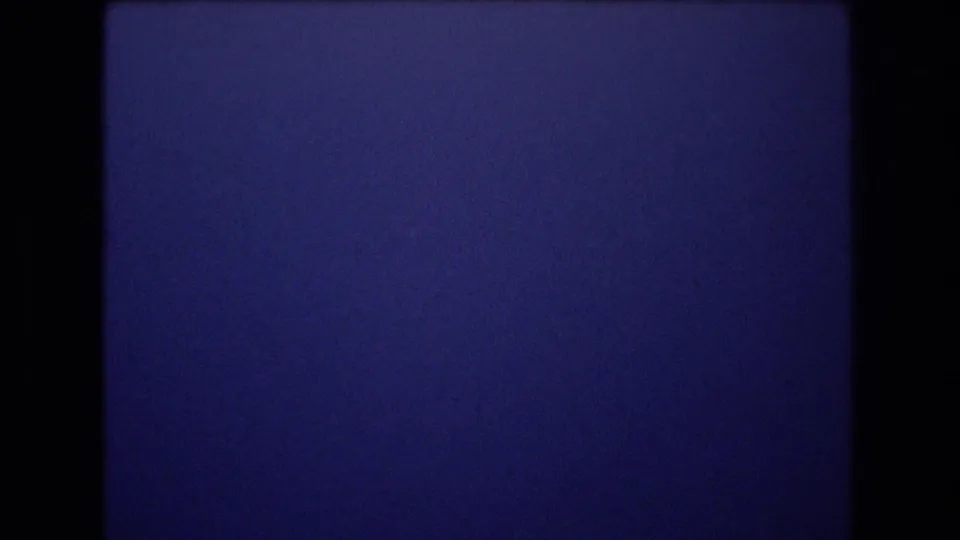 1977 Honolulu 8mm frame of deep blue sky with a subtle horizontal boundary across the image, film grain, and dark gate borders.