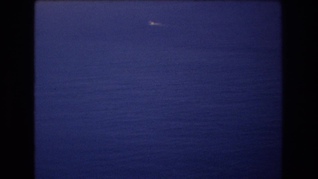 Calm open ocean and horizon with a small bright boat near the upper frame.