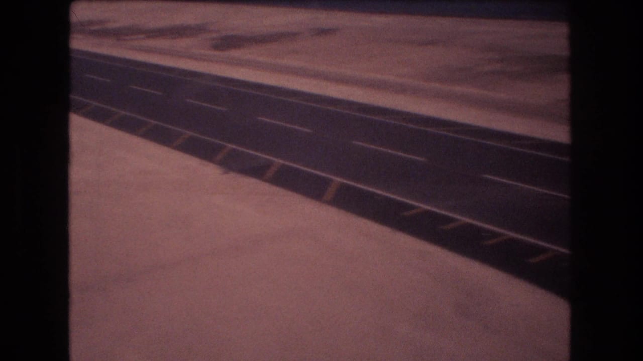 Long paved surface angles across a flat pale landscape with white dashed markings visible.