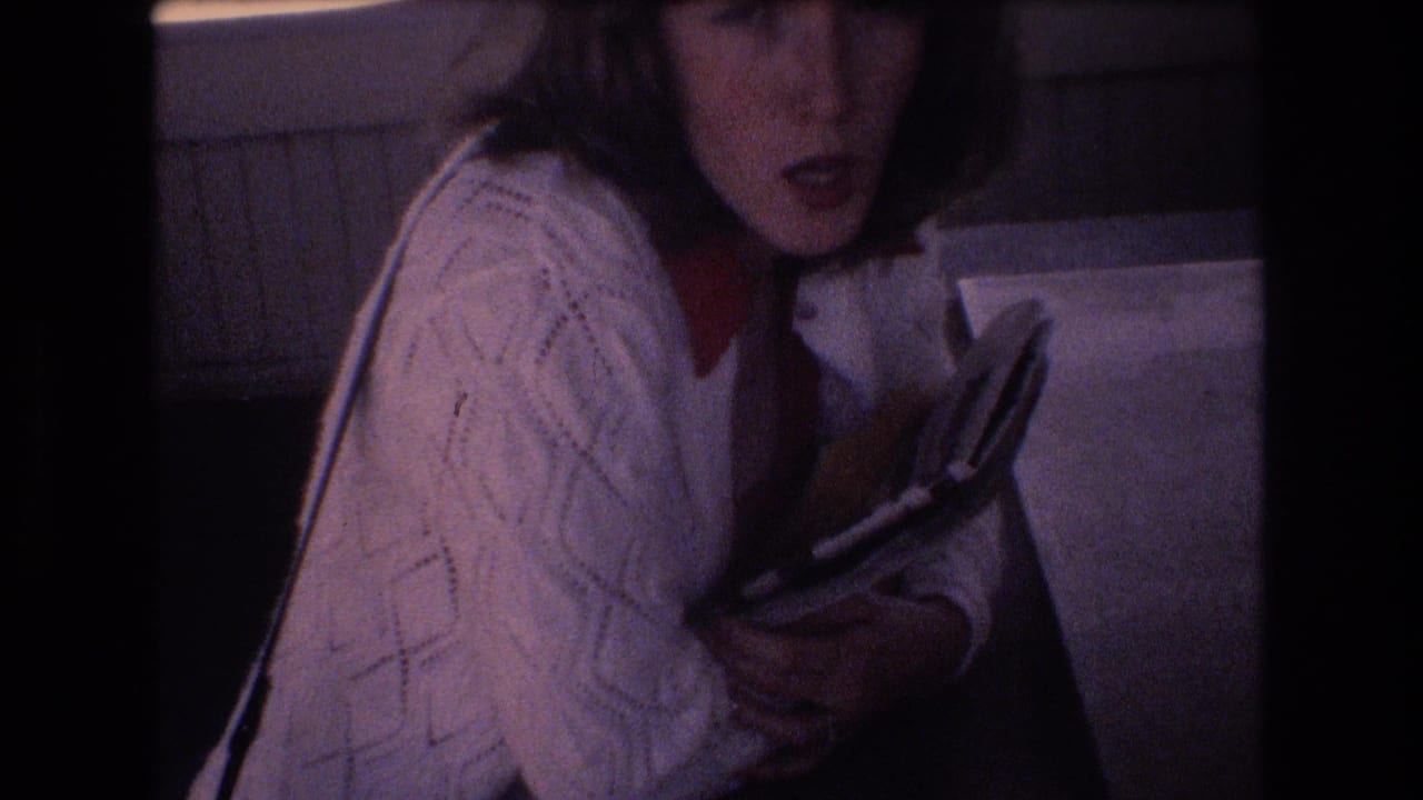 Woman turns with her mouth open while holding a book or magazine.