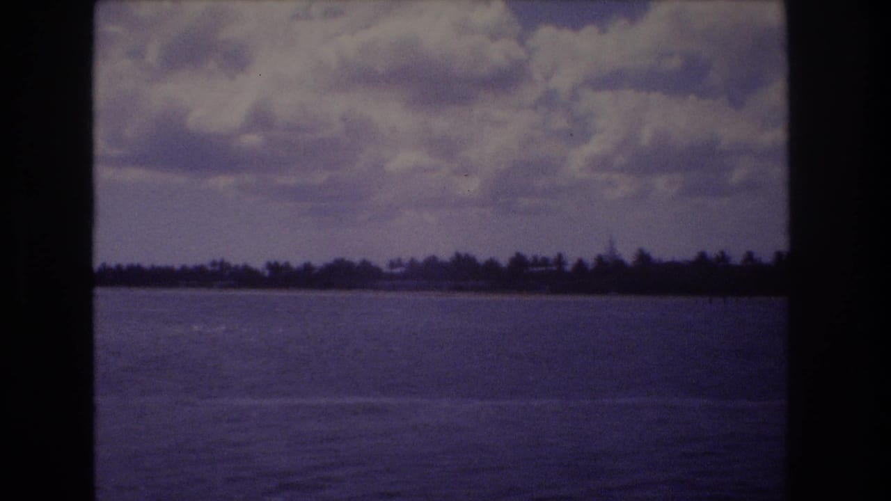 Open water and distant shoreline beneath a cloud-filled sky.