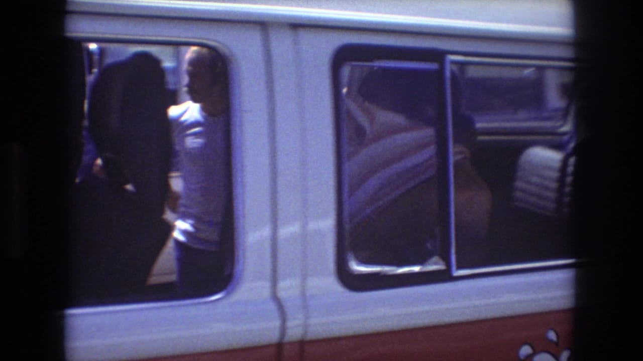 Woman in a white T-shirt visible in the open side doorway of a tour van.