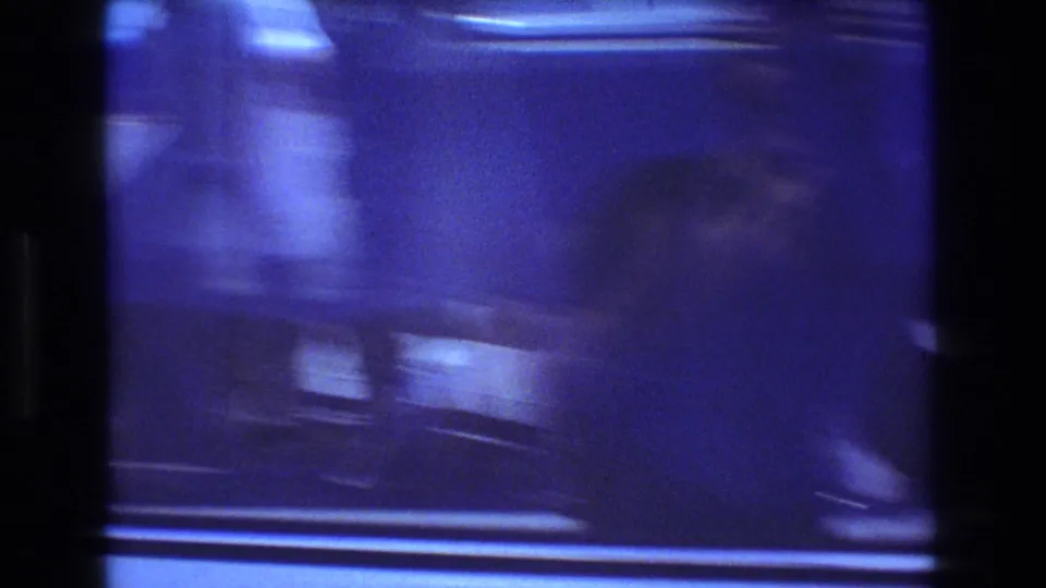 Blue-tinted final frame from the 1977 Honolulu van clip, with heavy motion blur, reflections, and only faint vehicle shapes visible through the window area.