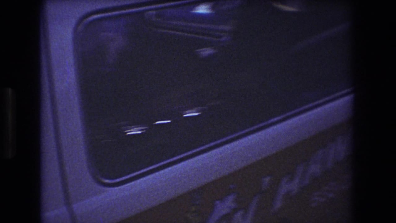 Side window of a white truck cab with a passenger faintly visible inside.