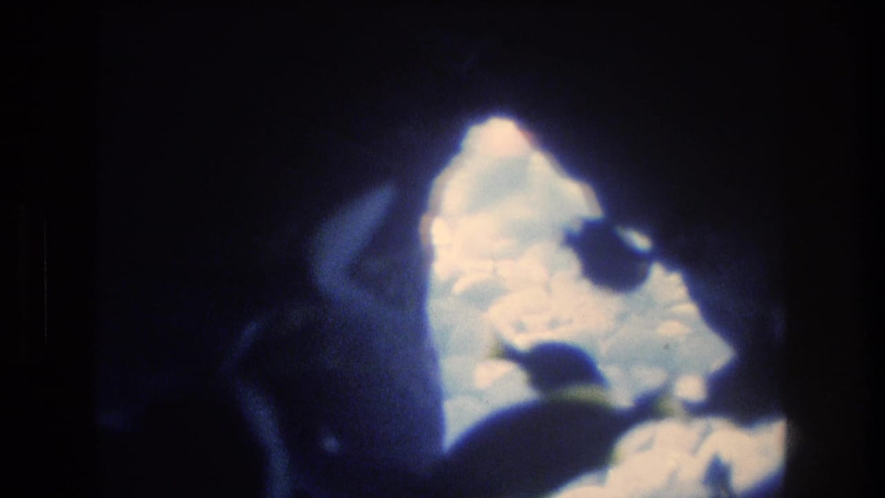 Bright blue-white water or sky seen through a dark cave-like opening.