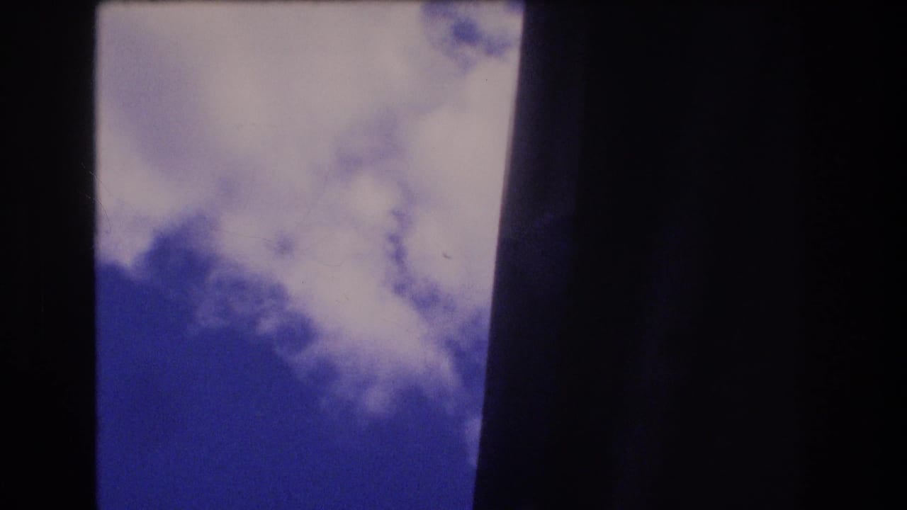 Cloudy sky bordered by dark vertical framing.