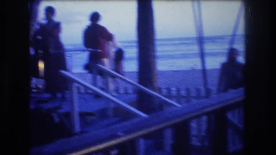 1977 Honolulu, Oahu, 8mm frame showing silhouetted passengers gathered by boat-deck stairs and railings with the ocean horizon beyond.