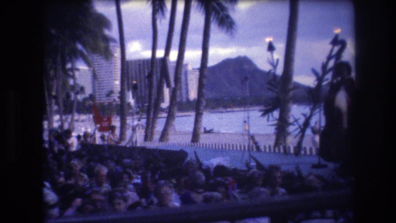 Beachside audience and torch-lit stage with Diamond Head across the water.