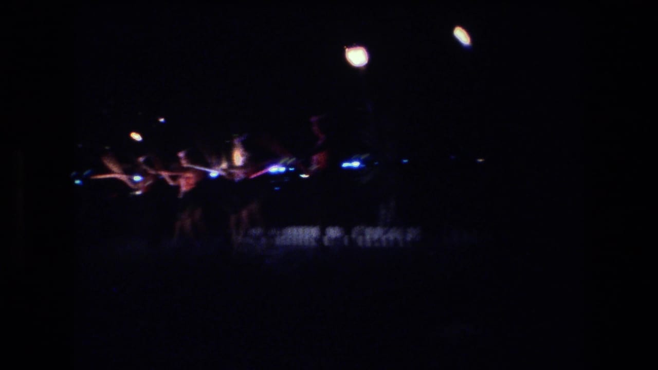 Distant night performance with torchlight and dark stage surroundings.