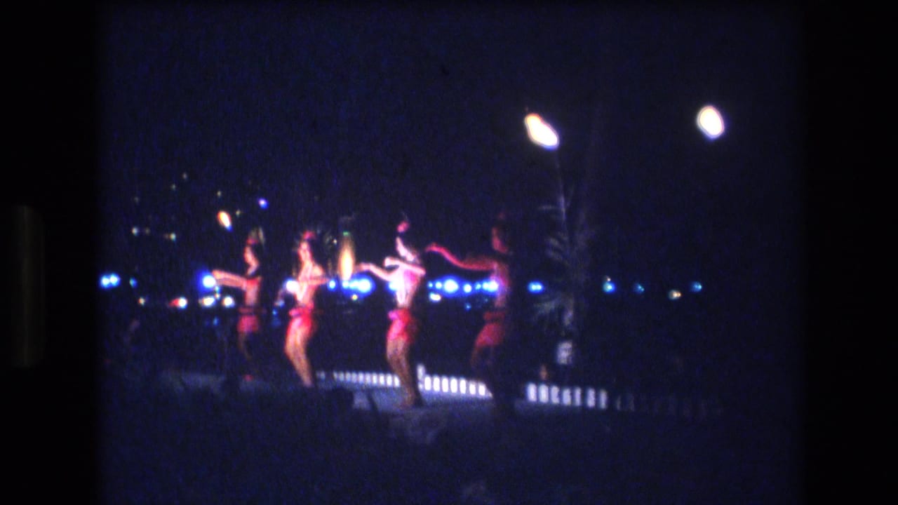 Group of women performing under lights in a dark outdoor setting.