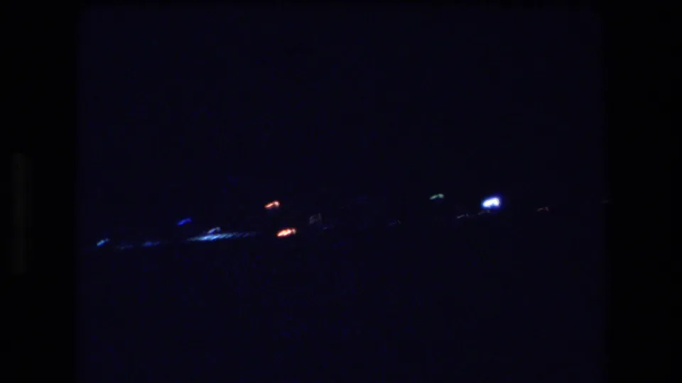 1977 Honolulu or Oahu 8mm frame showing scattered distant shoreline lights against a dark blue-black night view.