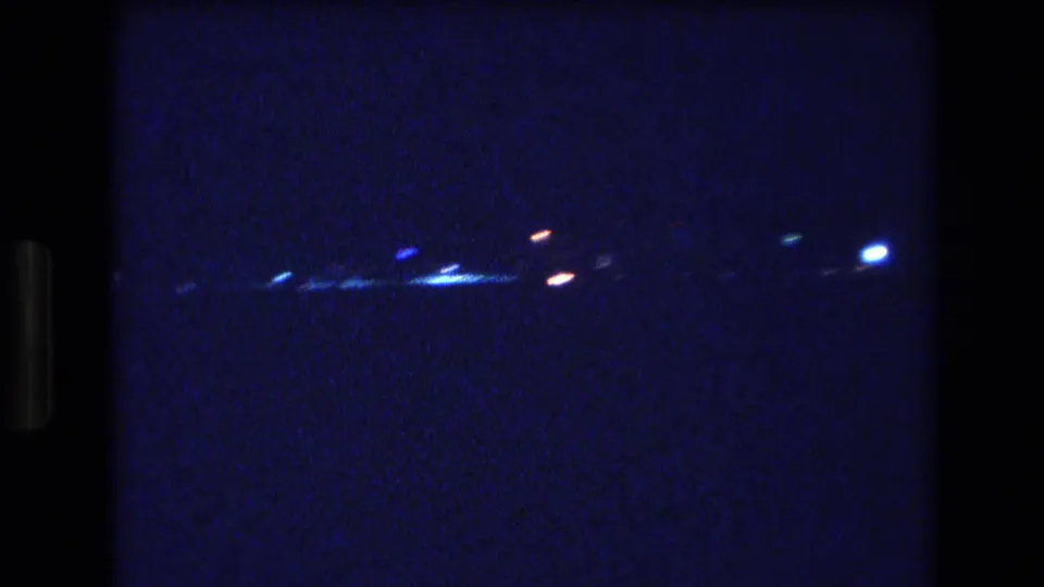 1977 Honolulu or Oahu 8mm night shot with brighter points of light along a distant dark shoreline or horizon.
