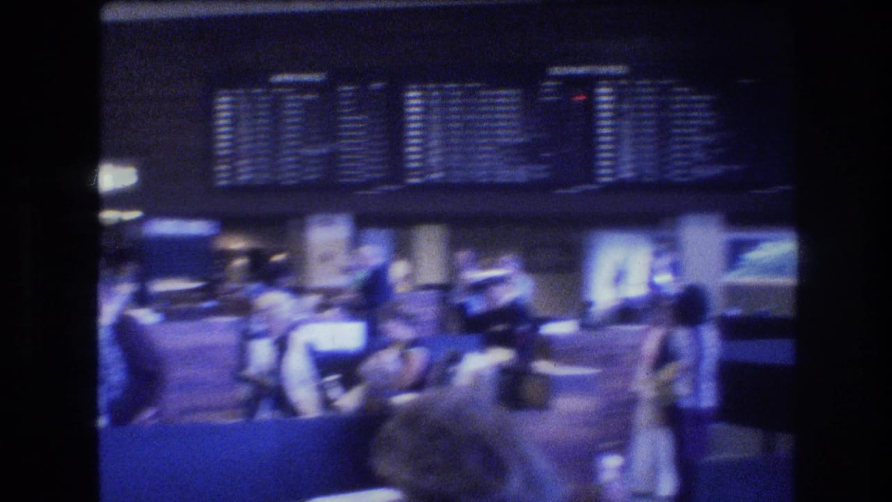 Travelers wait and move through a Honolulu airport terminal area in 1977, with flight information boards above counters and soft blue 8mm lighting.