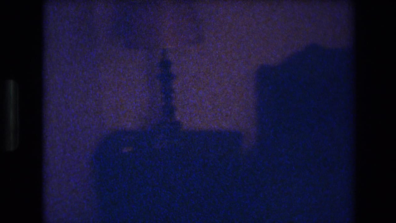 Near-black interior frame from a 1977 Las Vegas home movie showing silhouetted shapes in severe underexposure.
