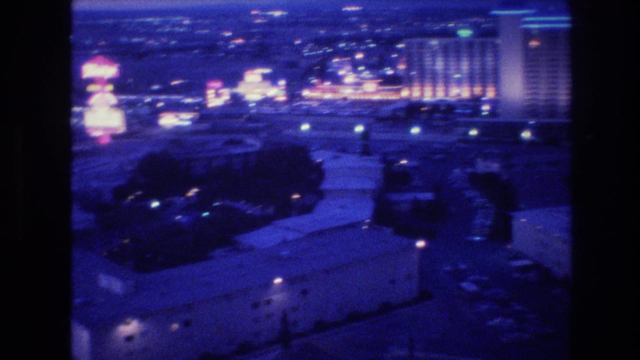 Nighttime view of illuminated Las Vegas hotel-casino buildings and surrounding roads.