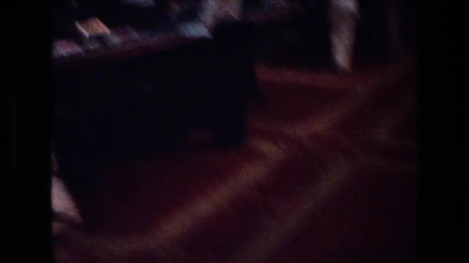 Handheld camera pan across a Las Vegas casino floor, circa 1977; patterned carpet with red tones and dark patron silhouettes visible through heavy Super 8 motion blur.