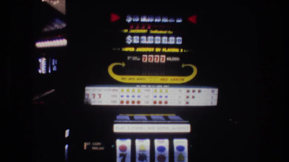 1977 Las Vegas casino slot machine showing illuminated jackpot dollar display, "7777" jackpot symbols, "WIN SUPER JACKPOT BY PLAYING 3 LINES" text, and "RED ARROW" brand arch, on 8mm film.