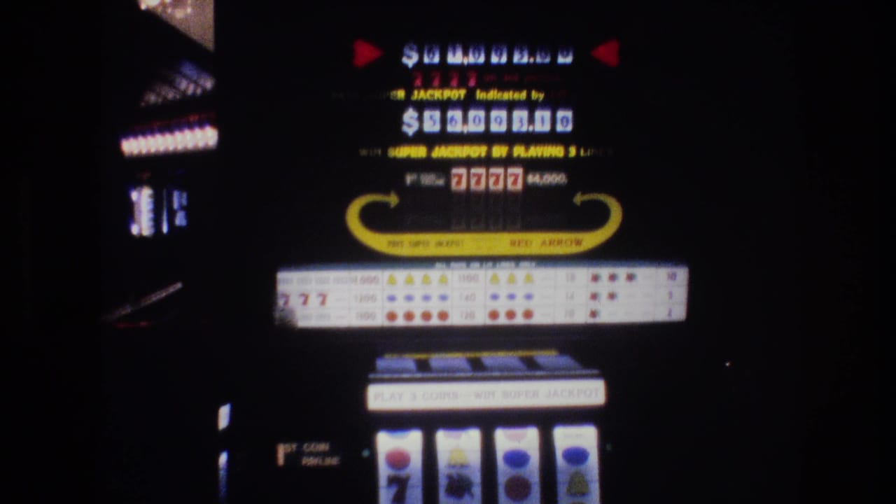 8mm footage of a Las Vegas slot machine display, circa 1977, showing jackpot readout, 7777 combination, and reel window with visible film grain.