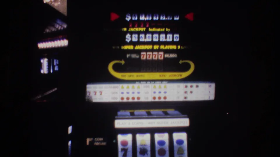 8mm footage of a Las Vegas slot machine display, circa 1977, showing jackpot readout, 7777 combination, and reel window with visible film grain.