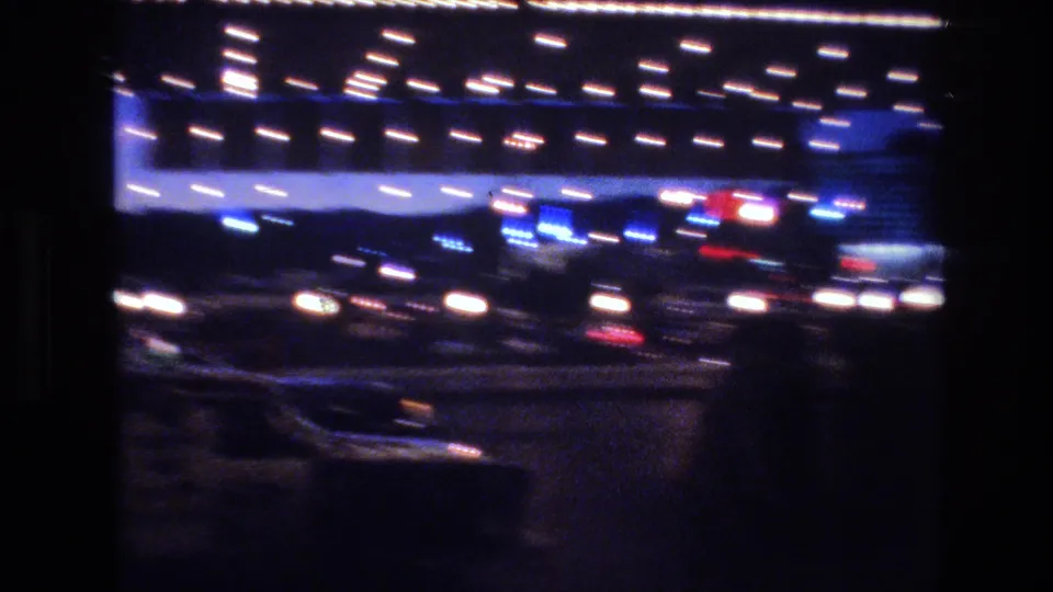 Motion-blurred 8mm shot of marquee bulb lights and blue commercial facade at night, Las Vegas area, circa 1977