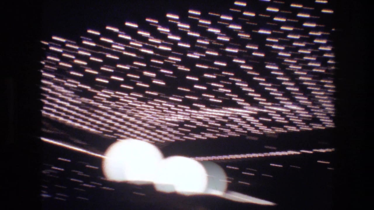 Blurred neon or marquee sign light grid, possibly Las Vegas commercial signage circa 1977, captured during heavy camera motion on 8mm.
