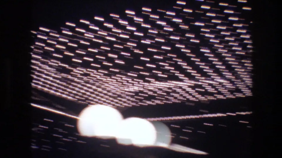 Blurred neon or marquee sign light grid, possibly Las Vegas commercial signage circa 1977, captured during heavy camera motion on 8mm.