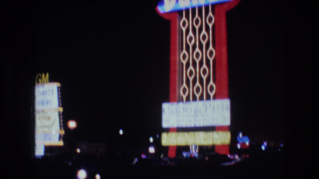 Tall illuminated casino marquee beside a dark street at night.