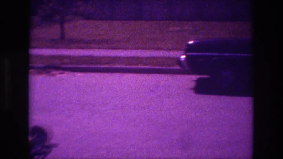 1981 San Diego 8mm frame with the sedan nearly out of view on a nighttime suburban street.