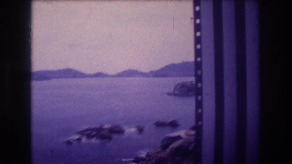 Acapulco Bay circa 1982, camera panned right to reveal rocky coastal outcroppings and a distant mountain ridgeline on 8mm home movie film.