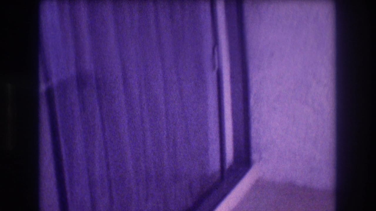 8mm close-up of a hotel room sliding glass door and curtains; heavy purple color shift consistent with aged 1980s film stock, Mexico.