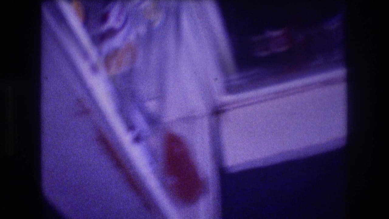Close-up of open refrigerator interior with white shelves and a red-labeled item on the door, heavy purple color cast from 8mm film.