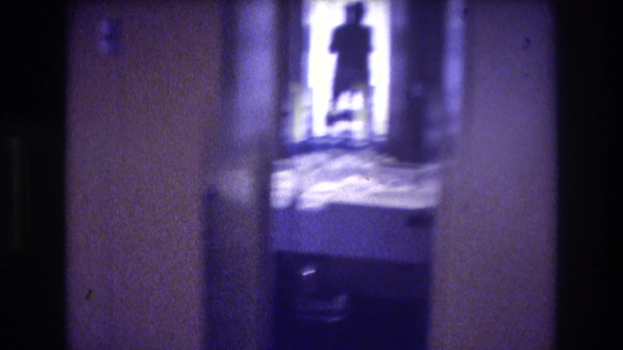 1982 Acapulco hotel room interior shot toward balcony doorway; warm orange wall tones contrast with overexposed outdoor light; one silhouetted figure visible.