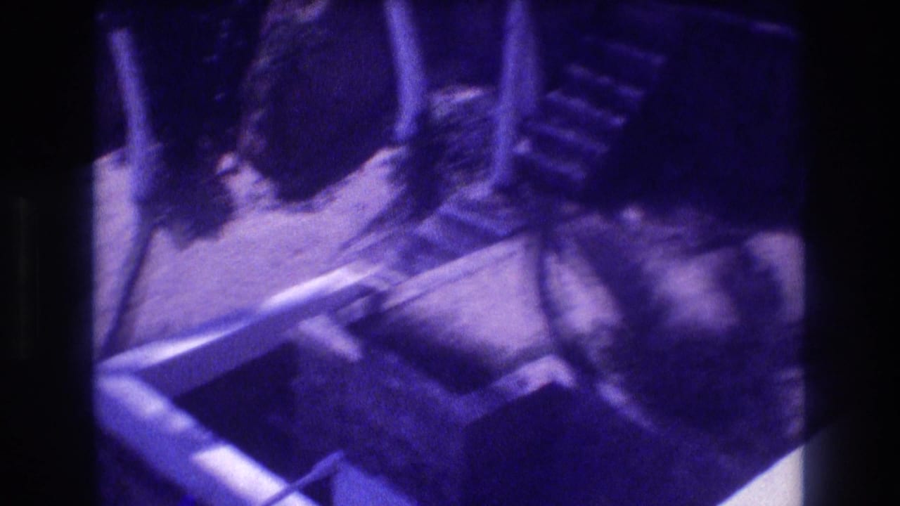 Looking down onto a concrete foundation under construction, Acapulco, Mexico, 1982; purple-cast 8mm footage shows wooden formwork, earthen floor, and a staircase form.