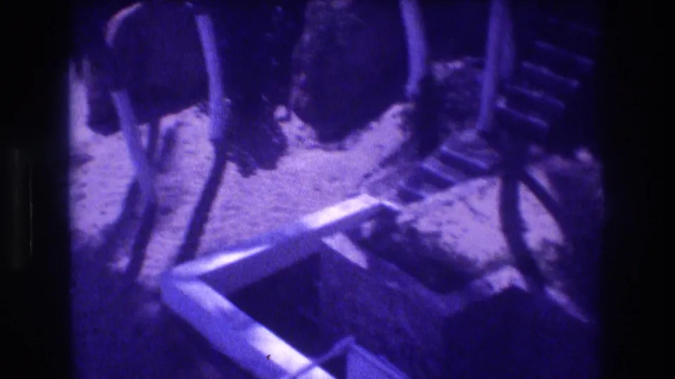 Vertical support columns and staircase formwork at an Acapulco construction site, 1982; camera panned to reveal a side view of the structure in aged 8mm with strong purple cast.