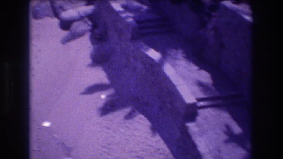 Camera-tilted view of rocks and what appears to be a concrete platform or plank, with lens flare and heavy purple color shift, 8mm home movie, Acapulco, Mexico, 1982.