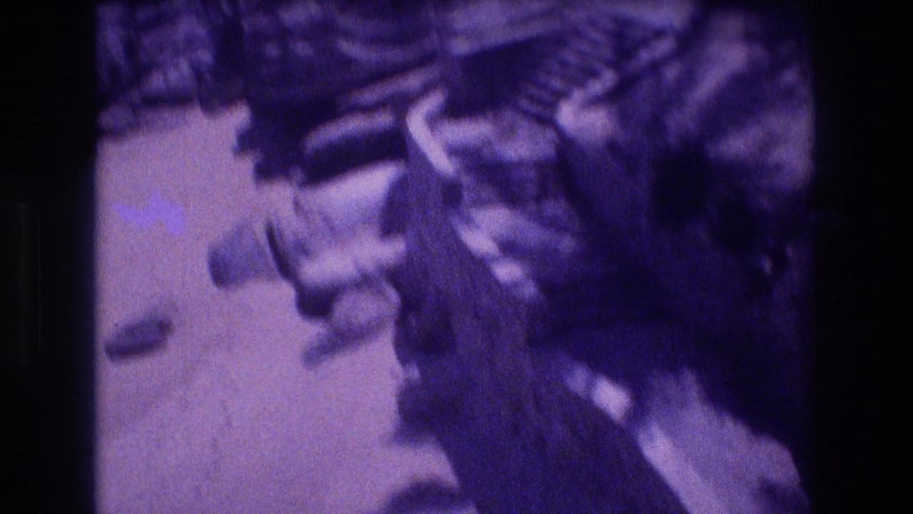 Close-up of dark rocky formations and scattered pebbles heavily blurred by camera movement with strong purple color shift.