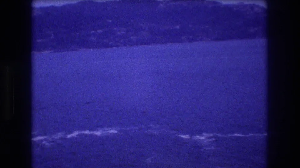 8mm home-movie frame from Acapulco, Mexico, circa 1982: broad bay during a slow pan with distant foothills and surf in the foreground.