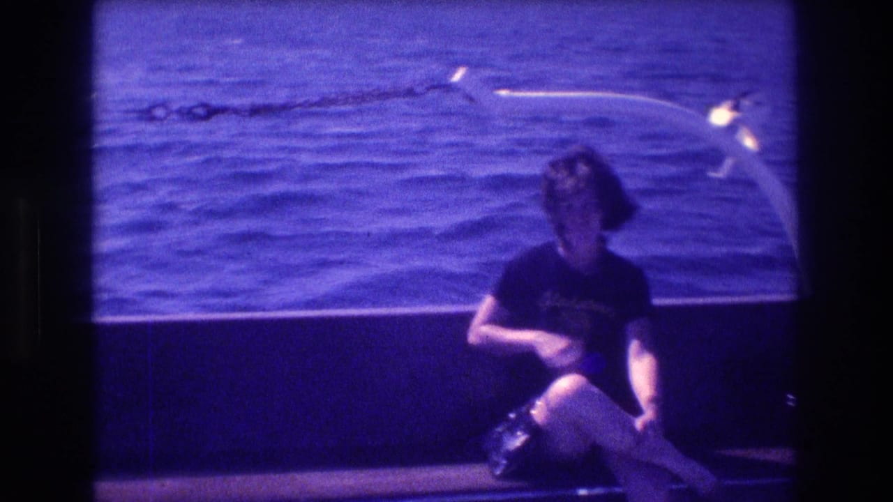 The woman remains seated on the boat in Acapulco, looking downward near a white curved rail with rippled sea in the background.