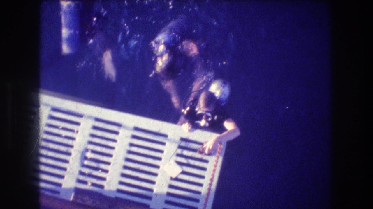 Two scuba divers beside a white slatted platform underwater.