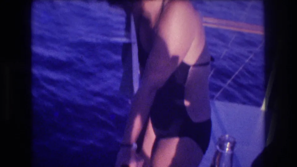 8mm close shot of a woman in a dark swimsuit on a dive boat deck, deep blue ocean visible behind her, Acapulco Mexico circa 1982.