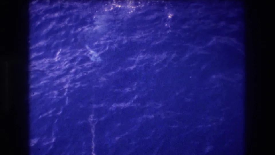 Super 8 home-movie view of ocean surface with wave patterns and light reflection, likely shot from a boat off Acapulco, Mexico, 1982.