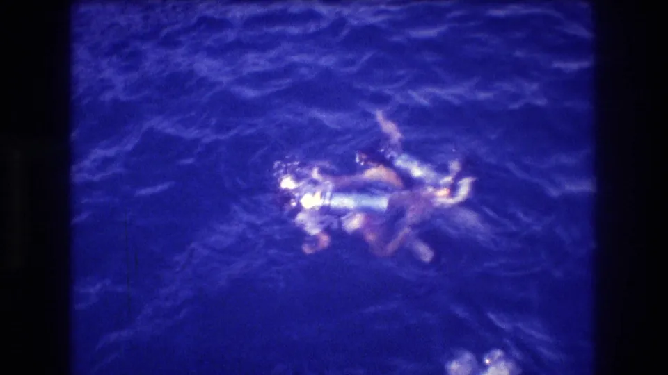 Two scuba divers on the ocean surface near Acapulco, Mexico, circa 1982, in close proximity, filmed on 8mm home movie stock.
