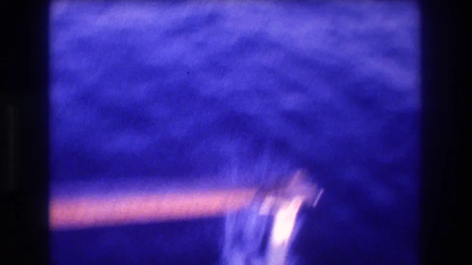 Transitional 8mm frame of open sea with a warm-toned boat railing partially visible at bottom of frame; Acapulco area, 1982.